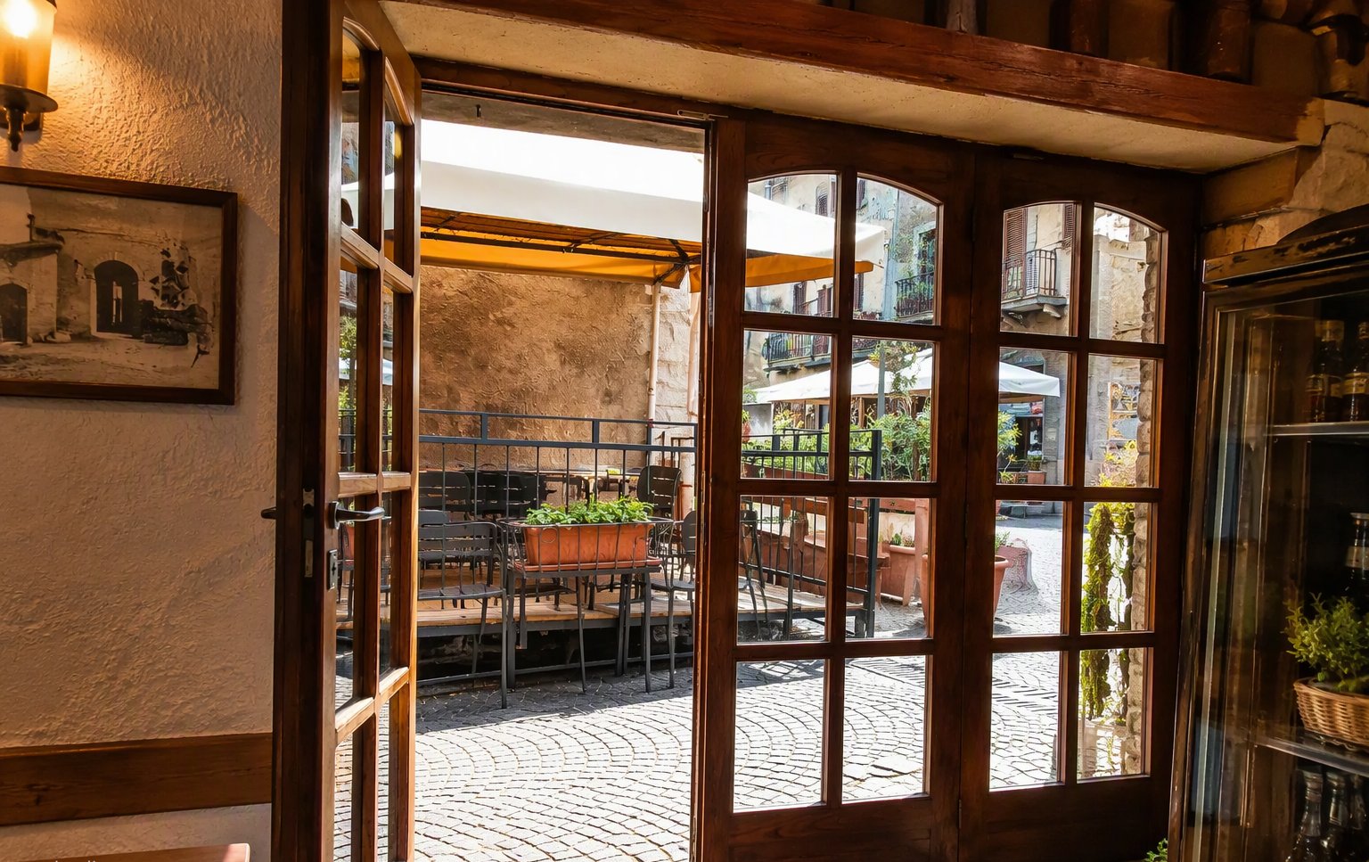Dalla porta del ristorante verso i tavolini sulla via di pietra